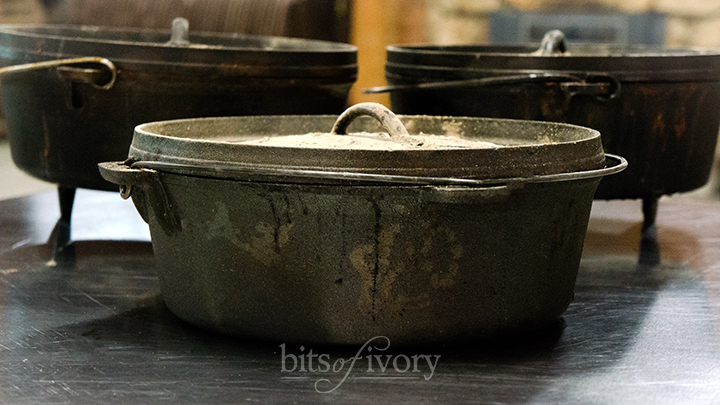 Three dutch ovens on a stainless steel table